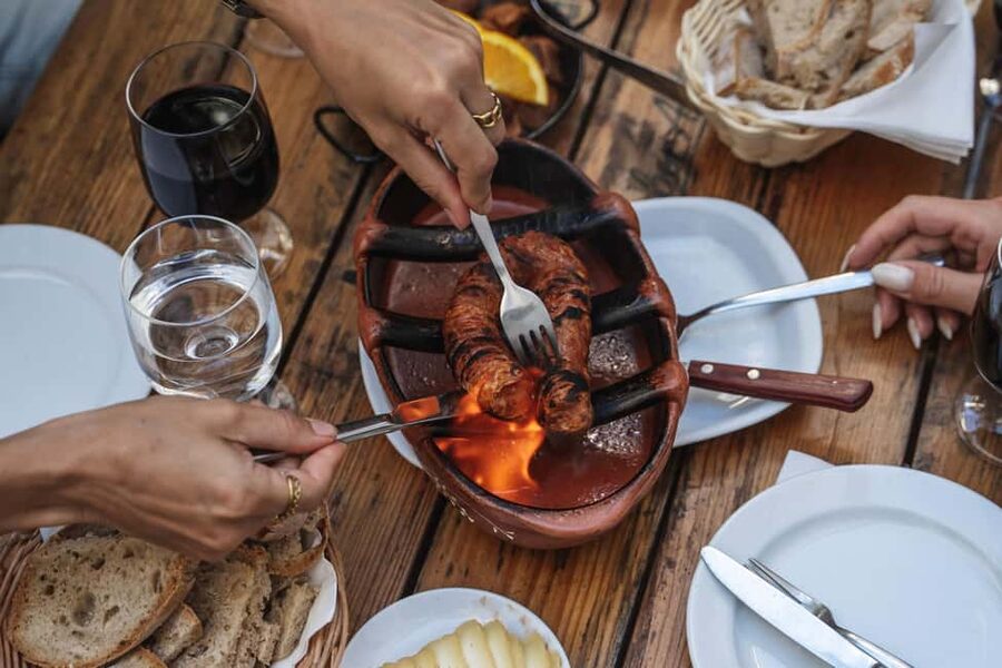 Eat & Walk Through Lisbon: A Local Food & Wine Experience - Meeting the guide beneath the Portuguese flag